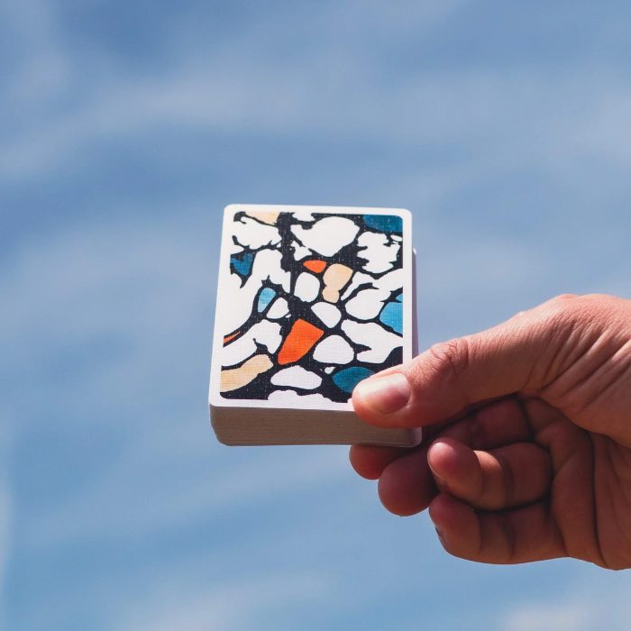 Mosaic playing cards held up against the sky